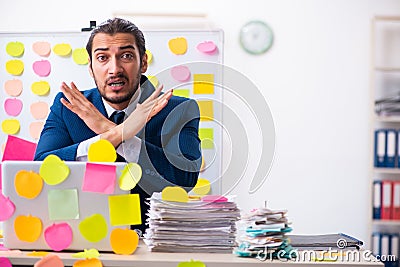 Young male employee in conflicting priorities concept Stock Photo