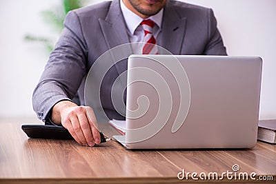 Young male employee inserting flash drive into laptop Stock Photo