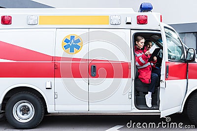 young male and female paramedics sitting Stock Photo