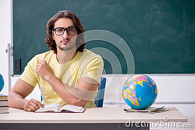 Young male geography teacher in front of blackboard Stock Photo