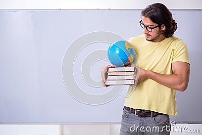 Young male geography teacher in front of whiteboard Stock Photo