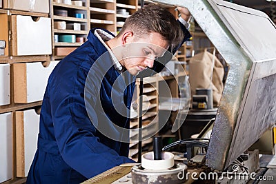 Young male joiner working with trimming machine Stock Photo