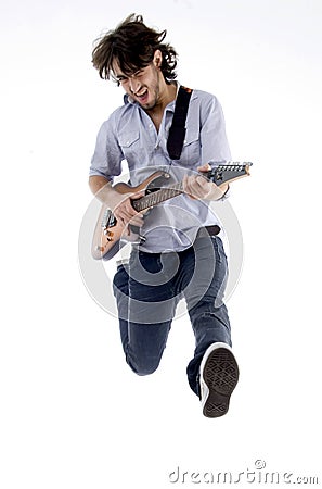 Young male jumping high holding his guitar Stock Photo