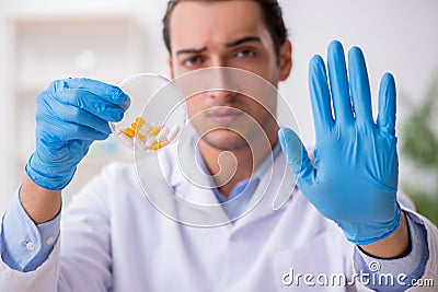 Young male lab assistant in drug synthesis concept Stock Photo