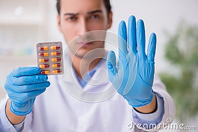 Young male lab assistant in drug synthesis concept Stock Photo