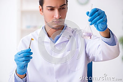 Young male lab assistant in drug synthesis concept Stock Photo