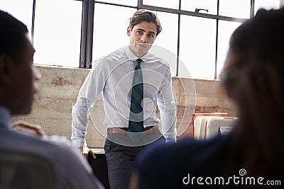 Young male manager listening to team at a meeting, close up Stock Photo