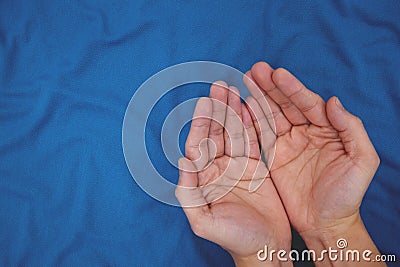 Young male open hands praying top view in dark blue background. Stock Photo