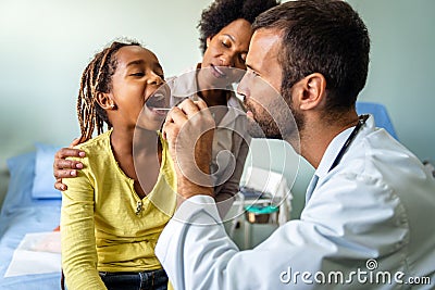 Young male pediatrician doctor examining child at office. Healthcare prevention exam people concept Stock Photo