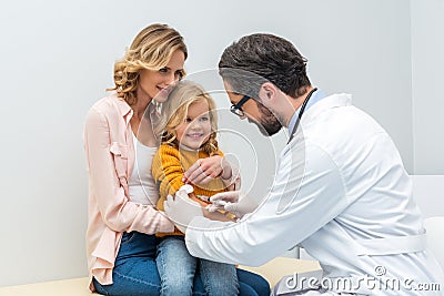 young male pediatrist making injection for little Stock Photo