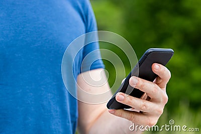 Young male person holding a mobile phone in his hand Stock Photo