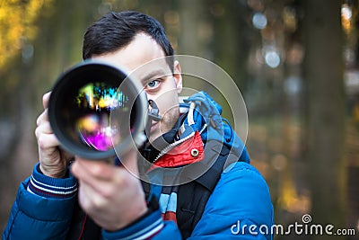 Young, male photographer taking photos with his huge Stock Photo