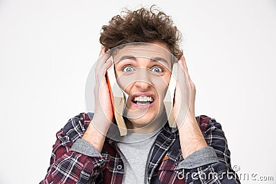 Young male student covering his ears with books Stock Photo