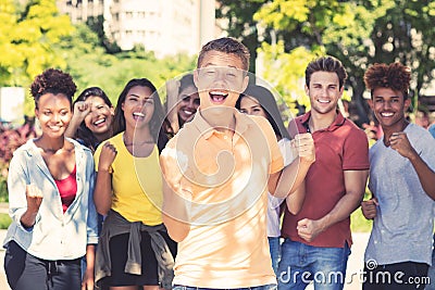 Young male student with group of cheering young adults Stock Photo
