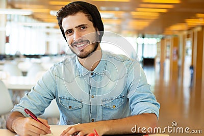 Young male student studying in the library Stock Photo