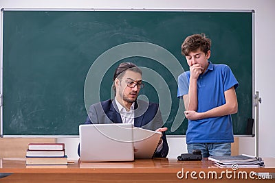 Young male teacher and schoolboy in the classroom Stock Photo