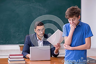 Young male teacher and schoolboy in the classroom Stock Photo