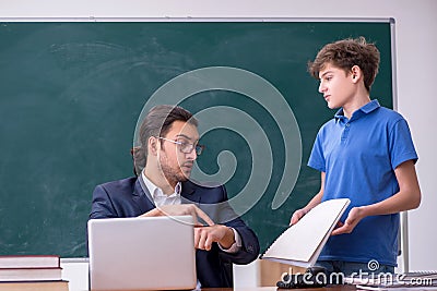 Young male teacher and schoolboy in the classroom Stock Photo