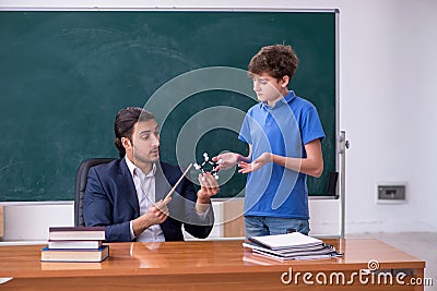 Young male teacher and schoolboy in the classroom Stock Photo