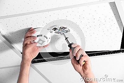 Young male technician installing smoke alarm system Stock Photo