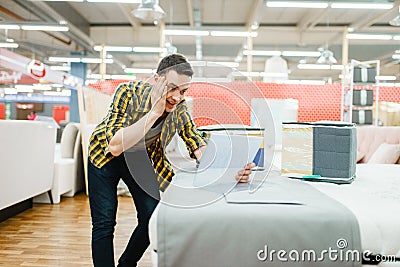 Young man afraids of the price in furniture store Stock Photo