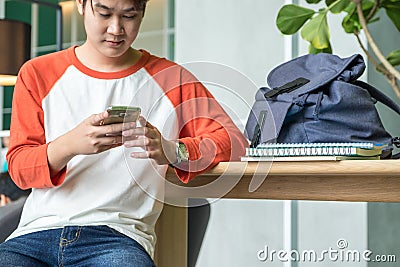 Young man asian teenager using mobile phone chatting with friend Stock Photo