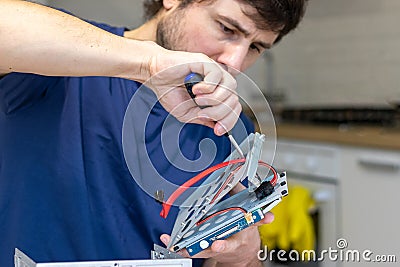 Young man assembles electronic computer components with his own hands. Hobby, technician, do-it-yourself assembly and invention Stock Photo