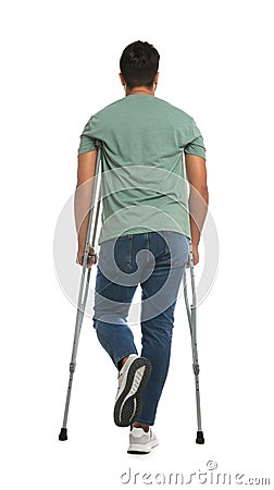 Young man with axillary crutches on white background, back view Stock Photo