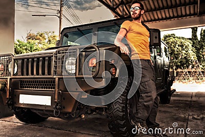 Young man on background army Hummer off road car Stock Photo