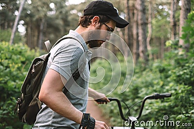 Young man with backpack cycling on a forest path, active lifestyle Stock Photo