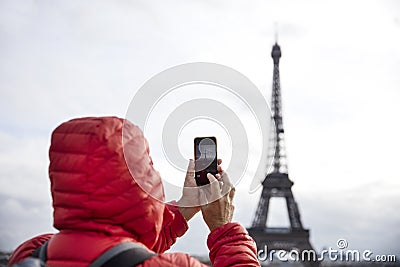 Young man with backpack taking photograph with mobile phone Stock Photo