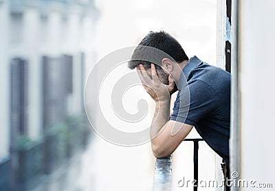 Young man at balcony in depression suffering emotional crisis and grief Stock Photo