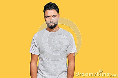 Young man with beard wearing casual grey tshirt skeptic and nervous, frowning upset because of problem Stock Photo