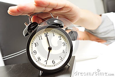 Young man in bed with a sleep mask stopping the alarm clock Stock Photo