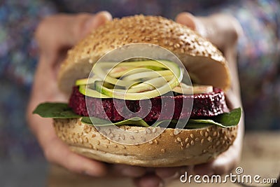 Young man with a beet burger sandwich Stock Photo