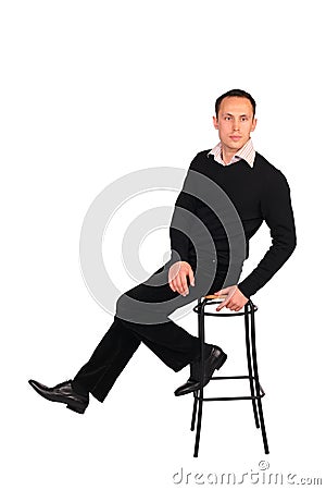 Young man in black sits on stool Stock Photo