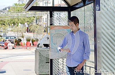 Young man at a bus stop Stock Photo