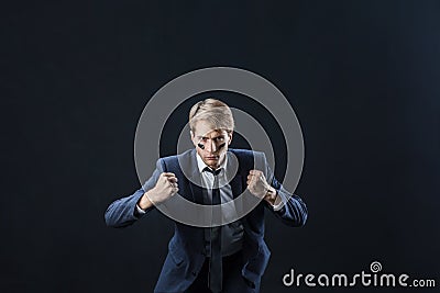 Young man in a business suit rolled up his sleeves and Boxing. Aggressive business, concept. Stock Photo