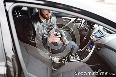 Young man with a camera in the car Stock Photo