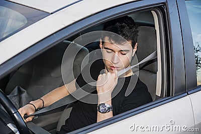 Young man in car fastening seat belt for safety Stock Photo