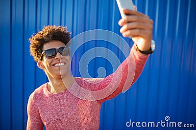 Young man in casual clothes make selfie over blue wall Stock Photo