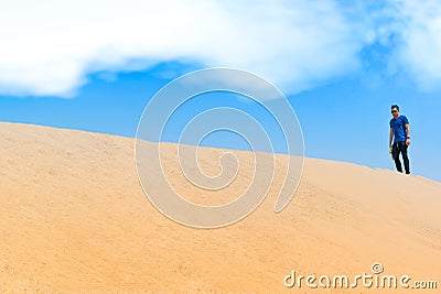 Young man in casual clothes walking forward in the desert Stock Photo