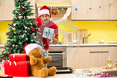 The young man celebrating christmas in kitchen Stock Photo