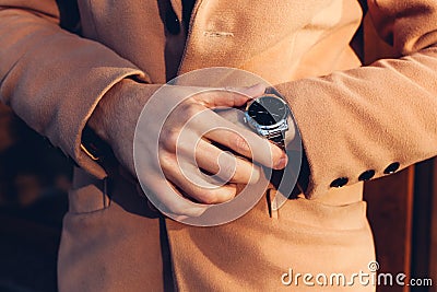 Young man checking time on stylish metal mechanical hand watch. Male accessories Stock Photo