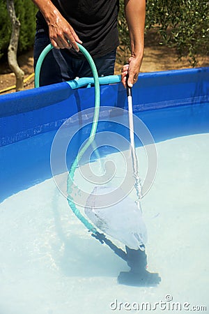 Young man cleaning a portable swimming pool Stock Photo