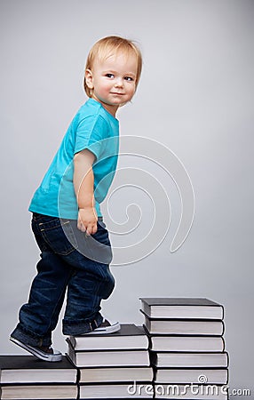 Young man climbing on a ladder of books Stock Photo