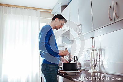 Young man cooking in the kitchen at home Stock Photo