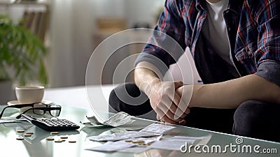 Young man counting home finance, few dollars and cents left to next salary Stock Photo