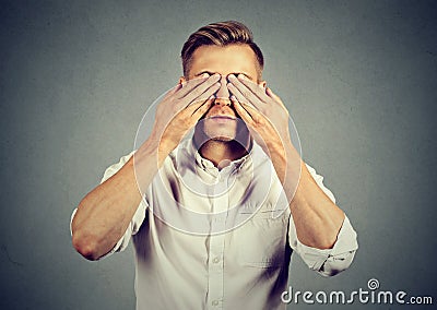 Young man covering eyes with both hands Stock Photo