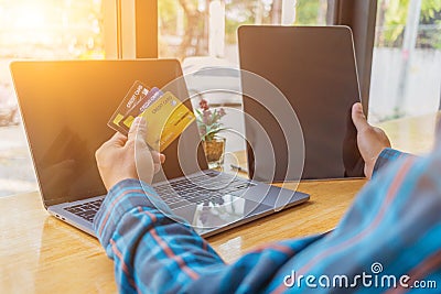 A young man with a credit card in his hand, sitting in agitation in front of a computer when he sees a debt collection document Editorial Stock Photo